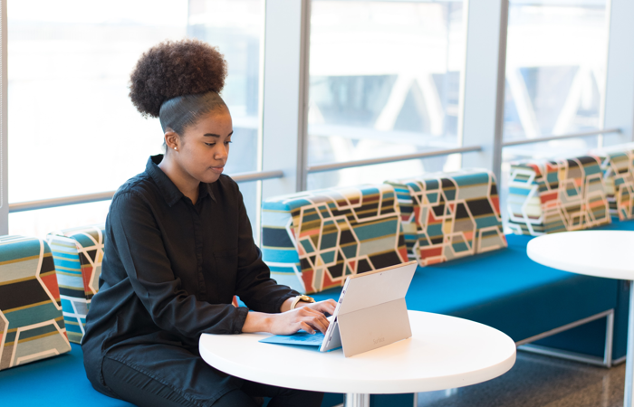 Kvinna sitter framför sin dator i en soffa